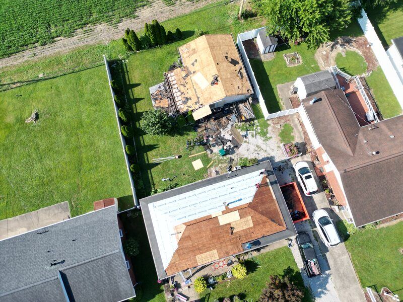 Aerial drone shot of two roofs being replaced simultaneously