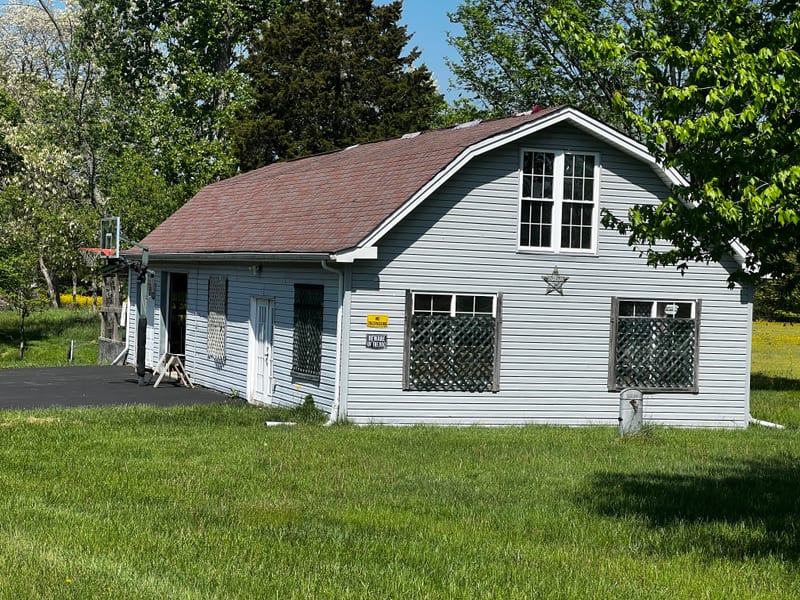 Ground-level end elevation of the gambrel-roofed building on evaluation day