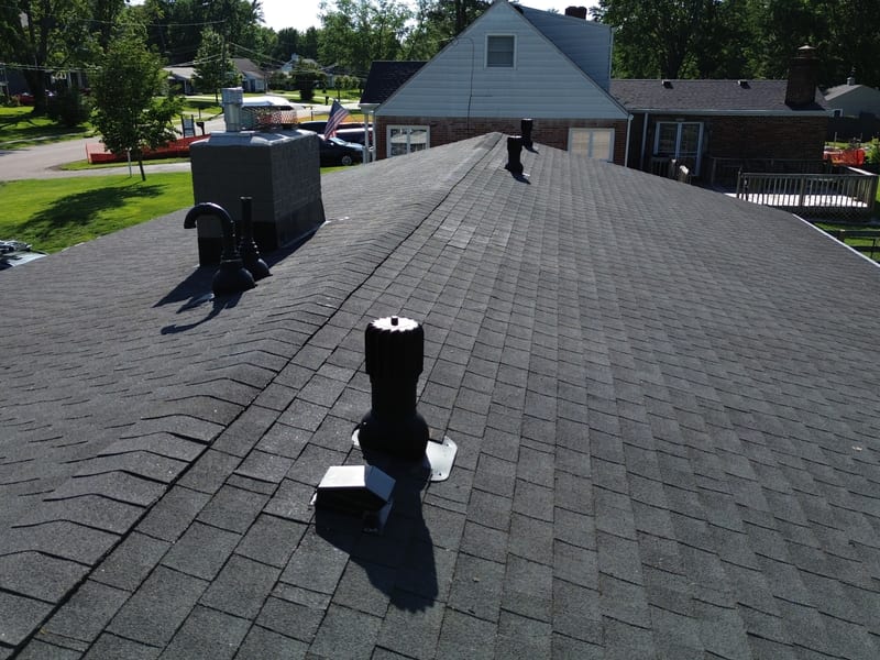 View down the ridge line showing the new Roofivent units, blacked-out gooseneck and plumbing stacks by the chimney