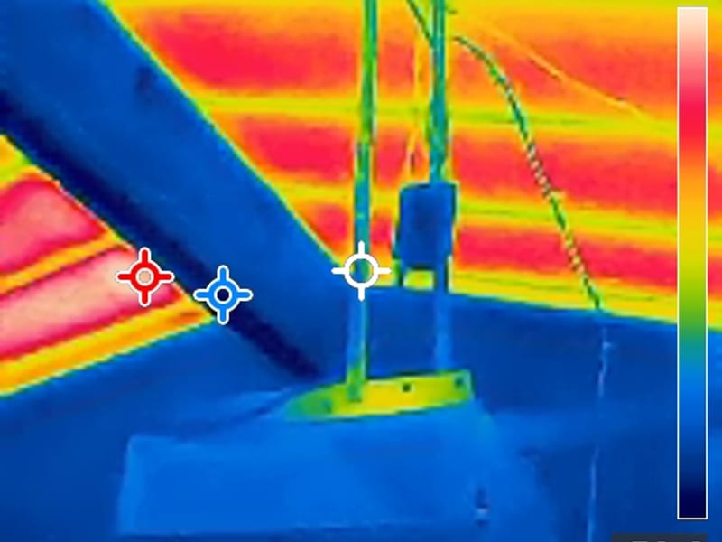 Second thermal camera frame of a roof vent base and pipes, cool roof plane against the warmer attic below
