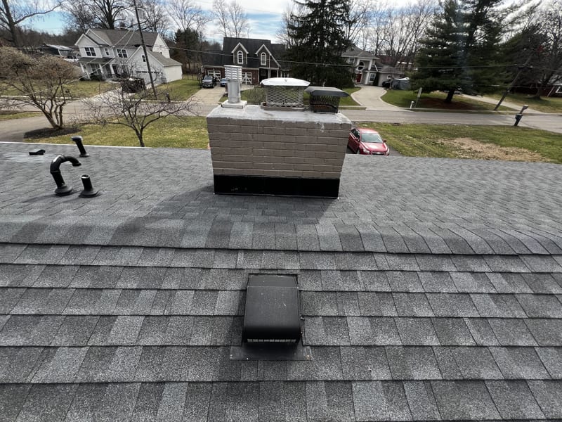 New Roofivent low-profile vents and the vent elbow beside the repainted chimney with its new caps