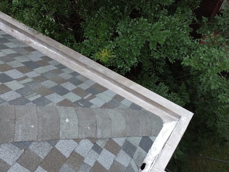 Close-up of the relined built-in box gutter running along the edge of the new designer shingles