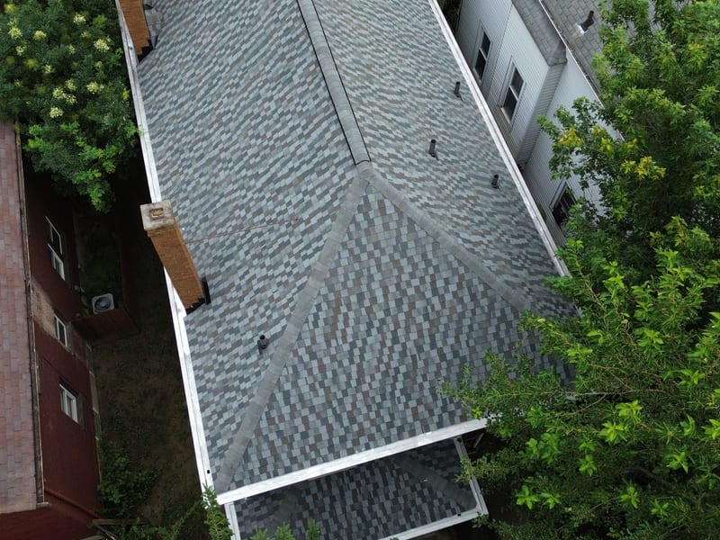 Straight-down view of the completed roof, the full hip-and-valley field finished in new shingle