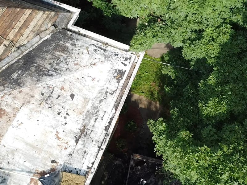 The bare low-slope roof section from above the rake, prepped before its new aluminum coating