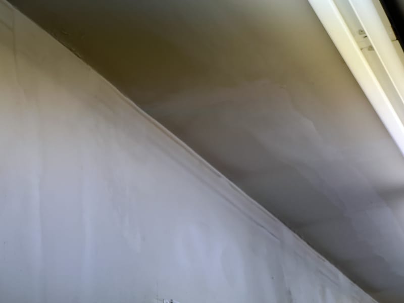 Crack along a ceiling-to-wall corner seam above a window