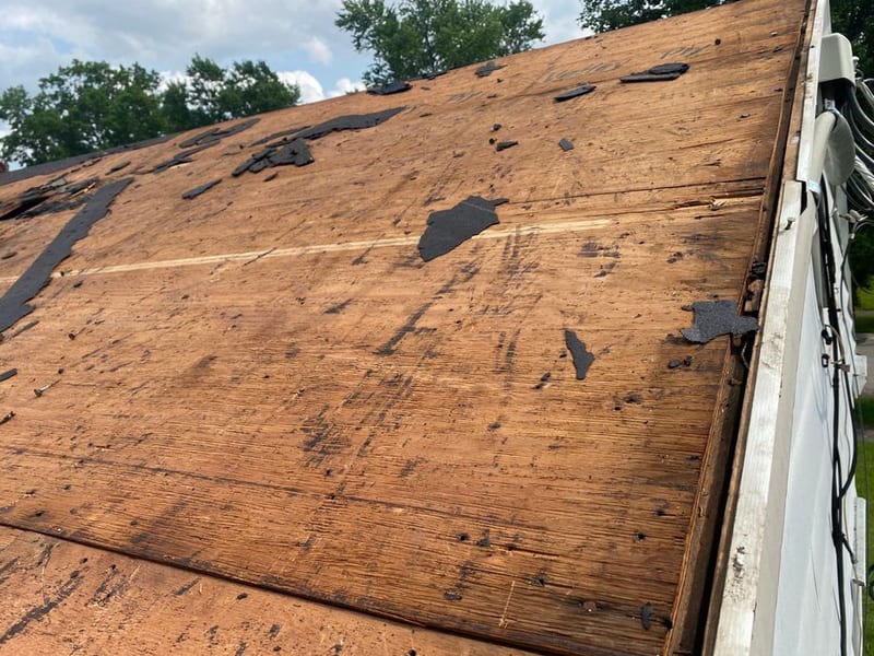 Close view of the exposed original plank decking with torn asphalt and old tar still stuck to the boards