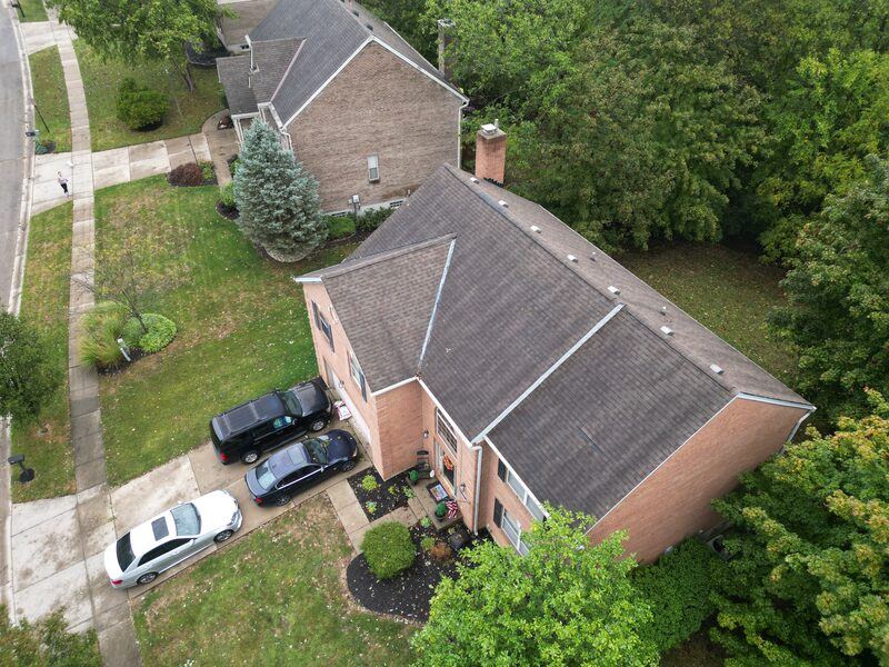 Aerial drone view of completed brick home roof replacement