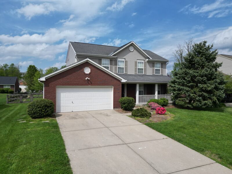Completed roof on brick colonial home with spring landscaping