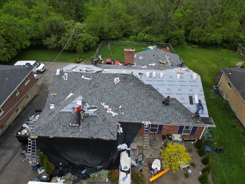 Afternoon progress: synthetic underlayment across the upper slopes with new shingle courses starting