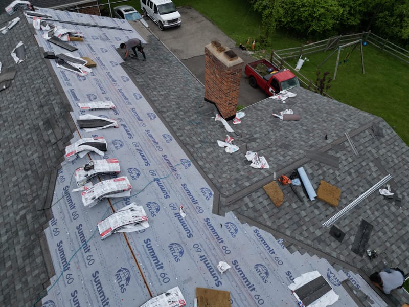 Detail down the main slope with underlayment laid and shingle bundles staged for the install