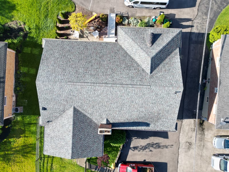 Top-down finished detail showing full shingle texture, a straight ridge line and clean valleys