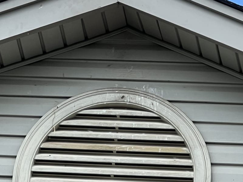 Gable roofline exterior with the soffit line closed and resealed after the repair