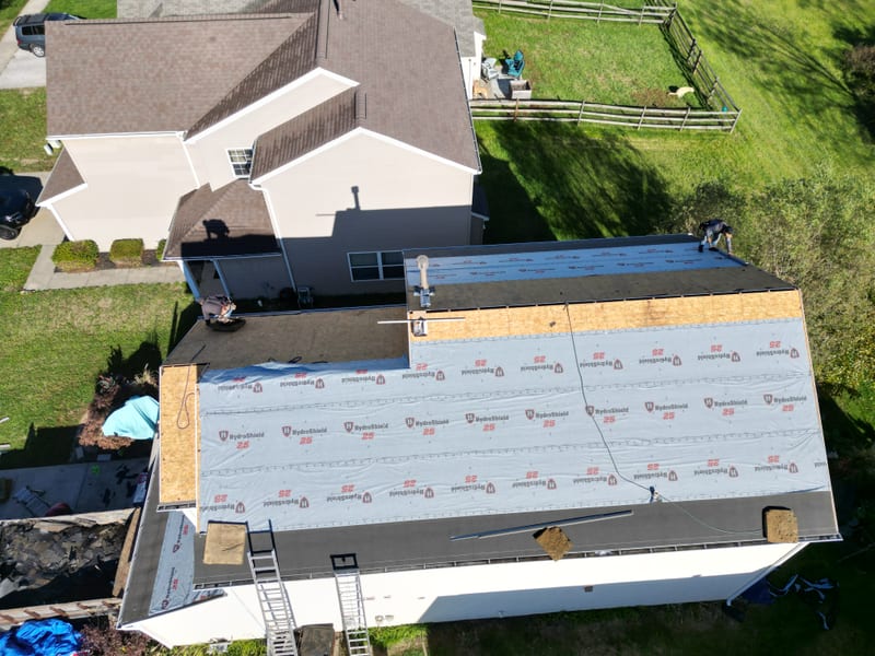 The full field covered in synthetic underlayment with new drip edge run out along the eaves