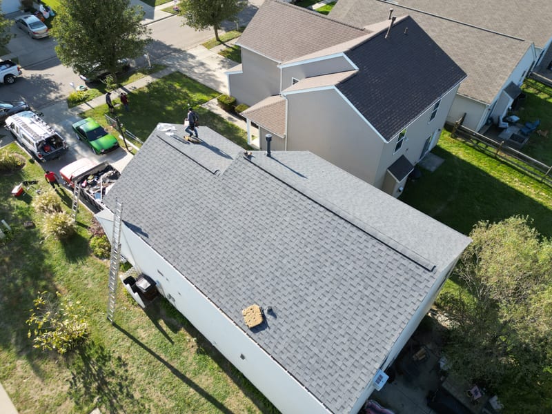 The finished roof the same afternoon with an even grey laminate field, clean ridge line and rake edges
