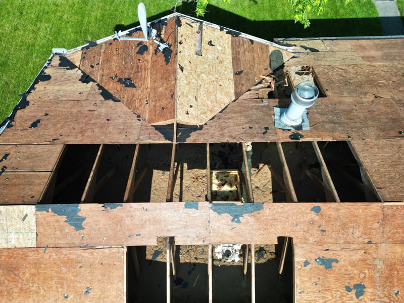 A new galvanised vent stack and flashed base set on cleaned deck beside a fresh sheet of decking