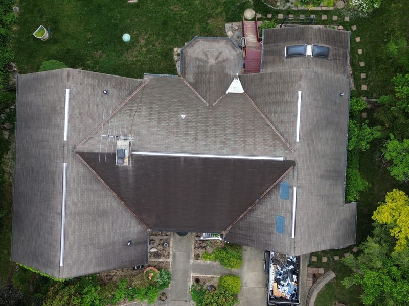 Straight-down aerial of the whole roof before tear-off, showing the hips, valleys, octagonal bay and two skylights