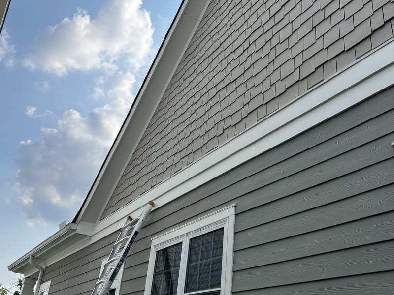 Extension ladder set against the front gable, looking up the elevation
