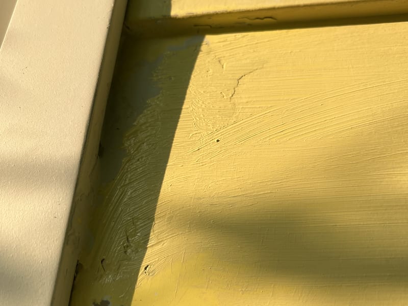 The finished repair painted to blend, brush texture feathered into the lap and up to the corner board
