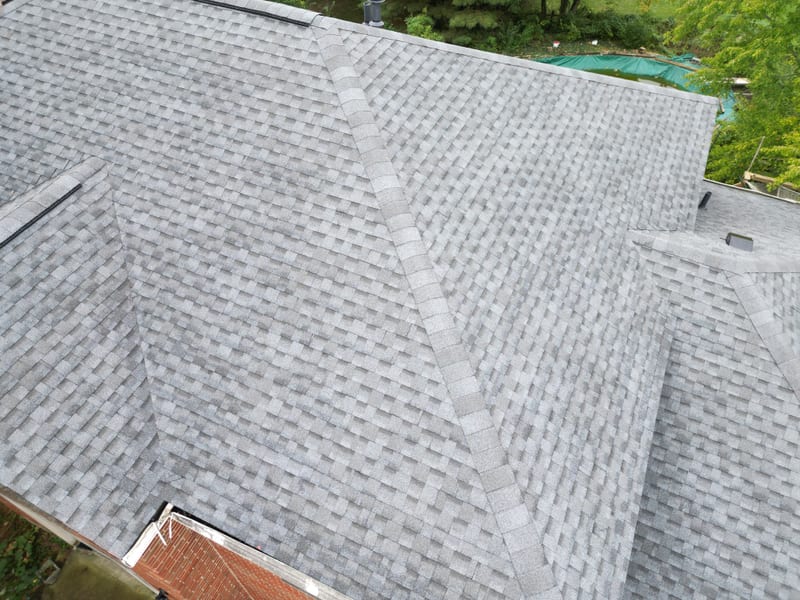 Finished detail: crisp valley lines, ridge cap and new pipe boots on the fresh shingle plane